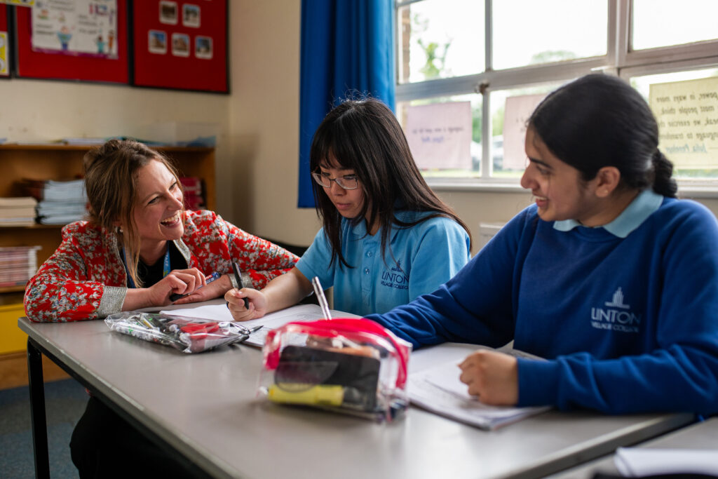 A teacher discussing work with two students.