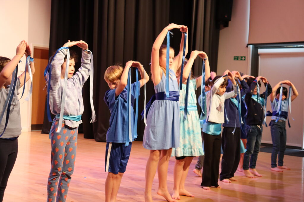 Pupils performing on a stage.