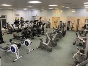 An indoor gym with gym equipment including a cycling machine and running machines.