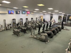 An indoor gym with gym equipment including a cycling machine and running machines.
