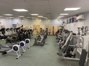 An indoor gym with gym equipment including a cycling machine and running machines.