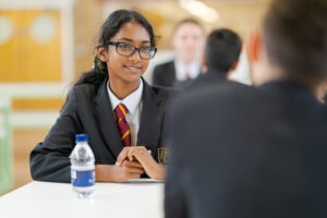 Two students smiling at each other.