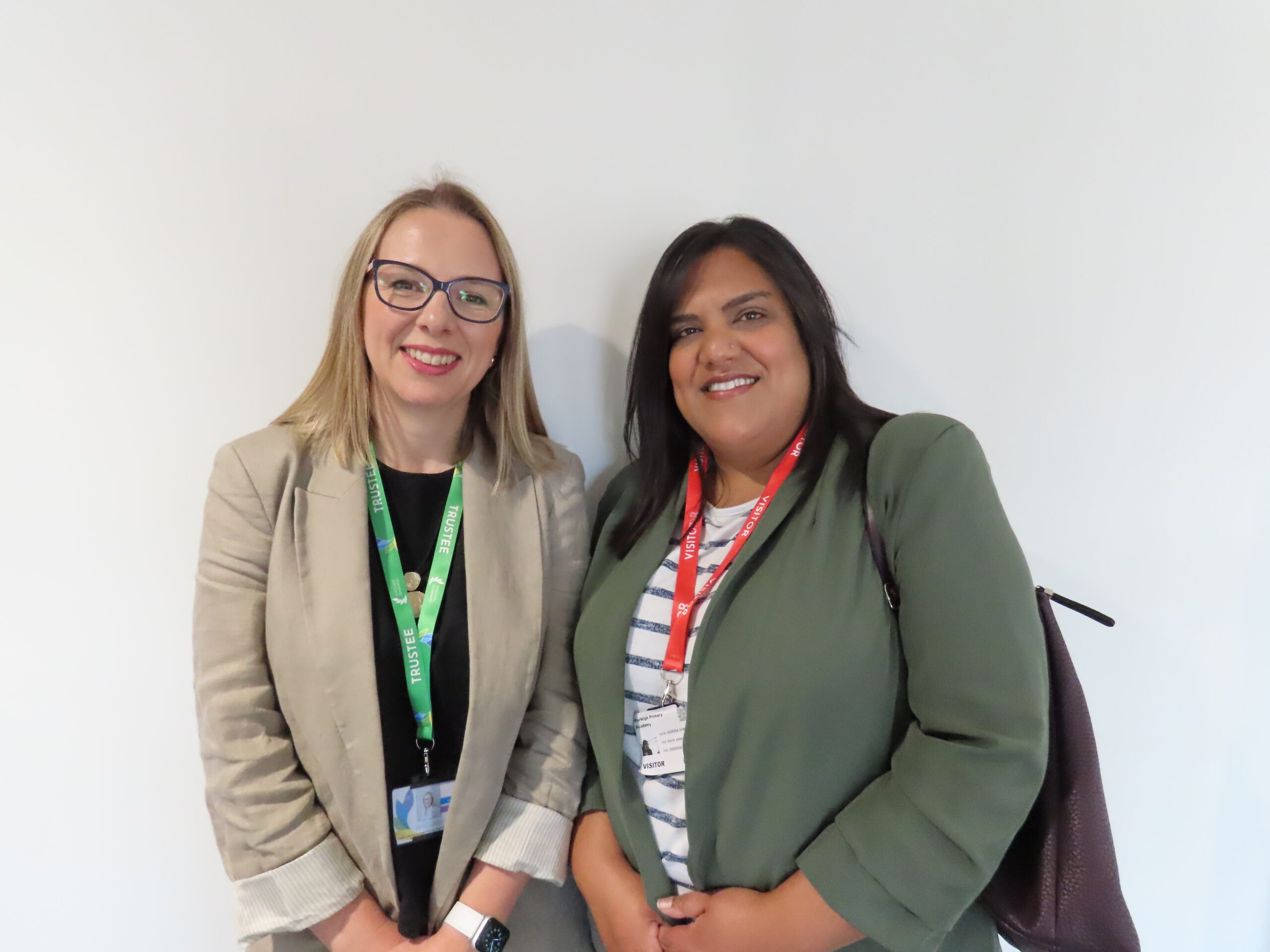 Two women are standing smiling at the camera.